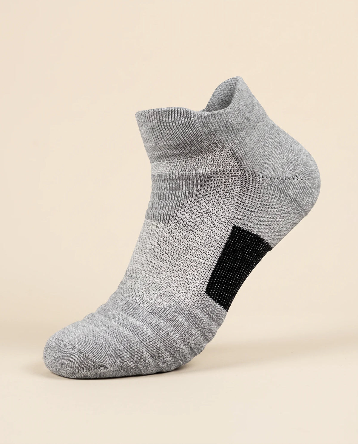 Gray low-cut court sock with black arch panel, three-quarter view