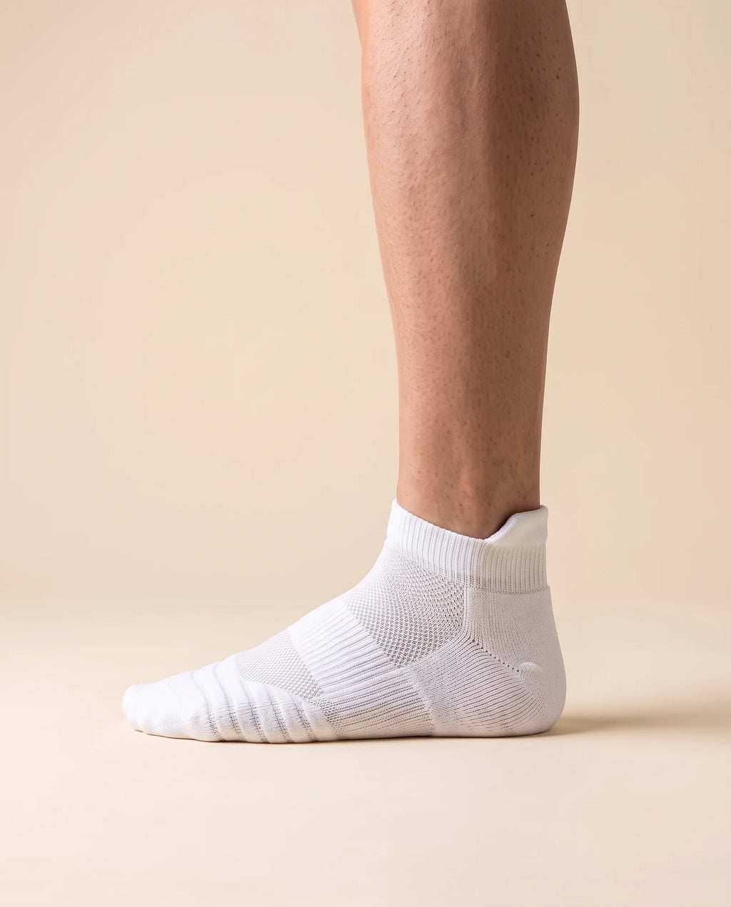 White low-cut court sock with padded heel tab, worn on foot, side view