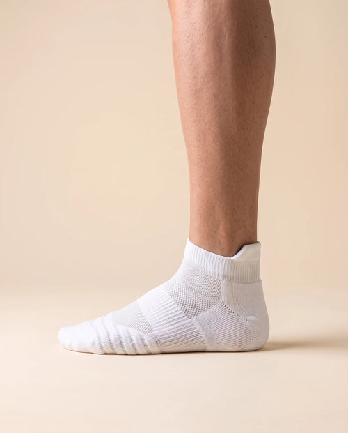 White low-cut court sock with padded heel tab, worn on foot, side view